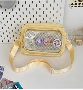Detail of yellow canvas itabag with transparent window and cartoon rabbit badges