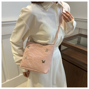 Vue détaillée de la texture plissée rose pâle avec ornements papillons en métal argenté