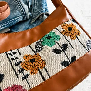Macro detail van retro canvas tas met geometrisch bloemenborduurwerk en bruin PU-leer