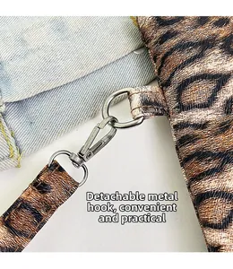 Detalle de gancho de metal plateado y correa de leopardo desmontable en bolso de mano