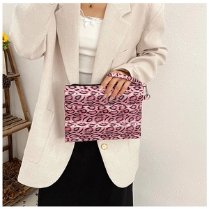 Vista detallada de bolso de mano rosa con estampado de leopardo, gancho y correa de muñeca
