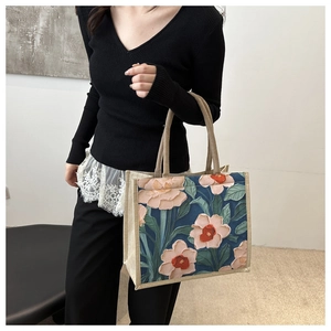 Detail of artistic floral tote bag with textured oil painting style and linen handles