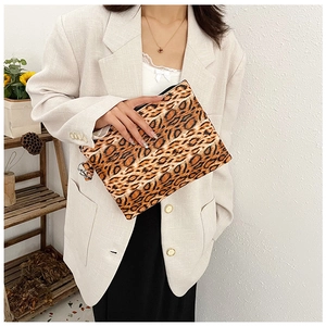 Detalle del bolso de mano de leopardo con cremallera metálica y acabado de cuero sintético