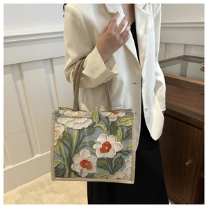 Detail view of artistic floral tote bag with textured oil painting style embroidery