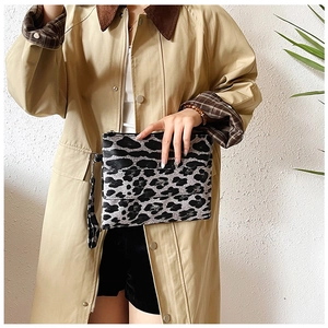 Detalle del bolso de mano con estampado de leopardo, cremallera plateada y asa