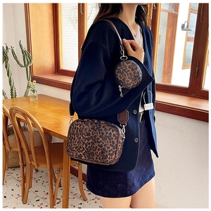 Vue détaillée du sac bandoulière léopard avec large sangle et petit porte-monnaie