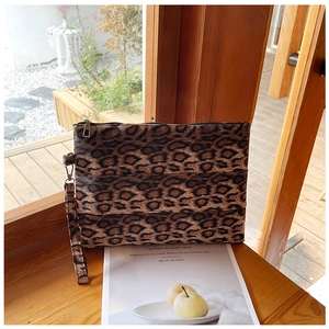 Primer plano detallado de un bolso de leopardo con cremallera metálica y correa de muñeca