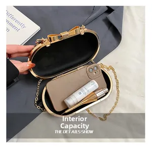 Detail view of gold metal oval clutch interior holding a phone and cosmetics