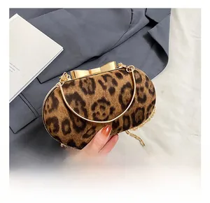 Detail of leopard print evening bag with golden bow clasp and metal chain strap