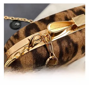 Close-up of leopard print fabric and gold metal chain clasp on a luxury evening bag