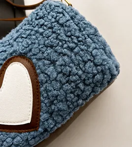 Close-up of blue faux shearling fabric and heart-shaped leather patch on a handbag