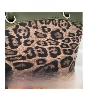 Close-up of leopard print fabric and dark green leather stitching on the bucket bag