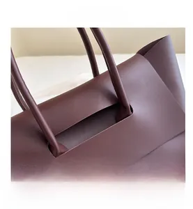 Detail of burgundy leather tote bag showing seamless integrated handle and premium texture