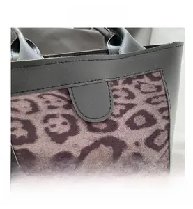 Close-up of leopard print texture and fine stitching on a black leather tote bag