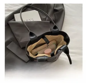 Top view showing large interior capacity of a purple textured tote bag with essentials