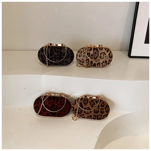 Detailed view of four leopard print crossbody bags with golden bow clasps and chain straps
