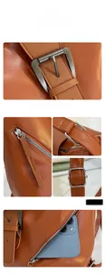 Detail of vintage brown leather tote bag showing metal buckle, zipper, and rear phone pocket