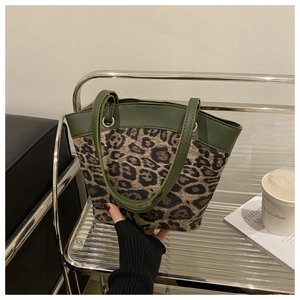 Detail showing leopard print texture and green leather handle of this tote bag