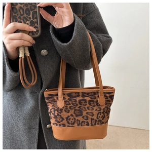 Detailed view of leopard print tote bag and matching phone case with brown leather base