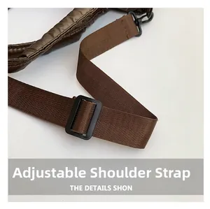 Close-up van de verstelbare bruine nylon schouderriem met gewatteerde textuur en haak