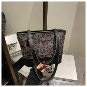 Detail view of the leopard print and black leather paneling on the shoulder tote bag