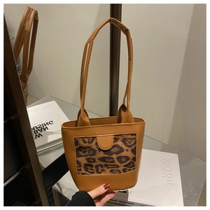 Detailed view of leopard print bucket bag with long top handles and leather texture