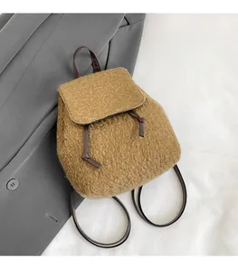Gros plan d'un sac à dos en laine camel avec cordon et lanières en cuir marron