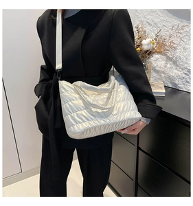 Détail du sac matelassé blanc à l'aspect nacré et large bandoulière ajustable