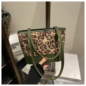 Detail view of leopard print suede and olive green faux leather on a bucket tote bag