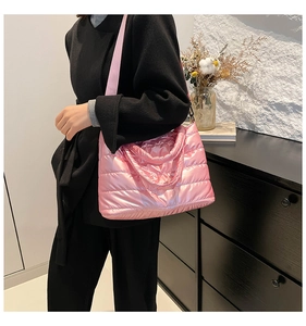 Detail der rosa gesteppten Puffer-Tasche mit glänzender Textur und breitem Schultergurt