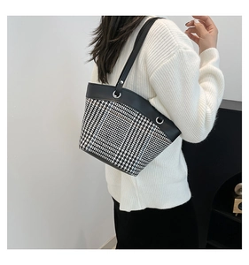 Détail de la texture pied-de-poule et de la bordure en cuir noir du sac à bandoulière chic