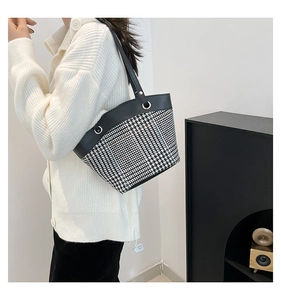 Gros plan sur un sac cabas patchwork à motif pied-de-poule avec poignées en cuir