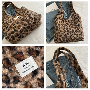 Detailed views of leopard print plush tote bag with white woven label on fabric background