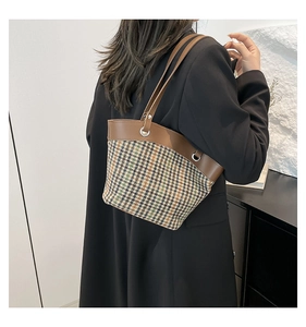 Détail du sac d'épaule en pied-de-poule avec finitions en cuir marron et boucles