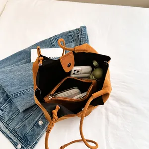 Spacious interior of brown suede bucket bag showing drawstring pouch and large capacity