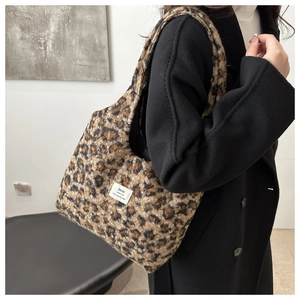 Detail of plush leopard print faux fur texture and branded woven label on tote bag