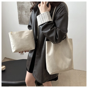 Dettaglio del set borsa a secchiello in pelle scamosciata bianco crema con pochette