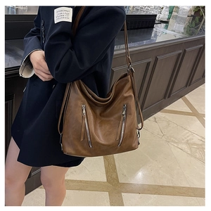 Détail du sac cabas vintage en cuir marron avec doubles fermetures éclair sur le devant