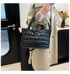 Détail de la texture en nylon matelassé noir brillant du sac cabas avec bandoulière