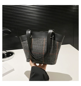 Détail du sac cabas à motif pied-de-poule avec rayures orange et poignées en cuir