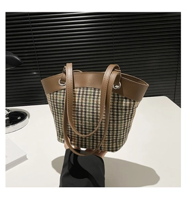Détail du sac cabas en tweed avec texture vert foncé et anse en cuir marron