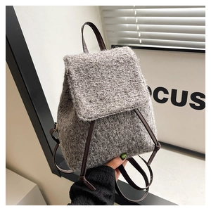 Close-up of grey textured wool mini backpack with slim brown leather straps and handle