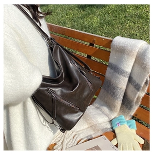 Détail du sac cabas en similicuir marron foncé avec fermetures éclair en décor extérieur