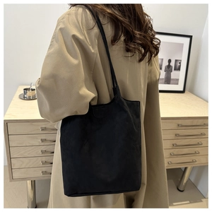 Sac fourre-tout noir chic porté avec un trench beige pour un look décontracté