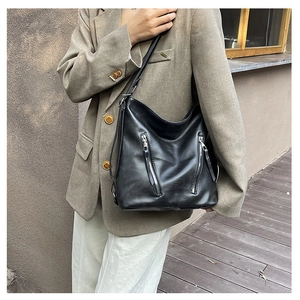 Détail d'un grand sac hobo noir en cuir avec doubles fermetures éclair sur un mannequin