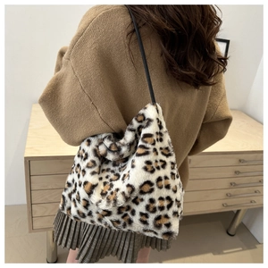 Dettaglio della borsa tote in peluche leopardata con sottile tracolla nera indossata
