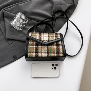 Close-up of retro plaid crossbody bag with smartphone to show mini size and texture
