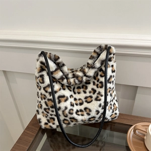 Borsa tote leopardata in ecopelliccia con spalline in pelle nera su tavolo in legno