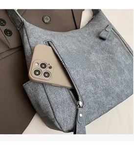 Macro shot of functional zipper front pocket on grey textured hobo tote bag