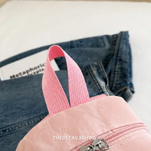 Detailed macro view of the soft pink nylon bag comfortable handle with silver zipper